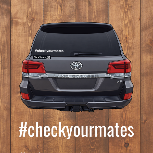Back view of a Toyota Land Cruiser with '#checkyourmates' vinyl lettering on a wooden background